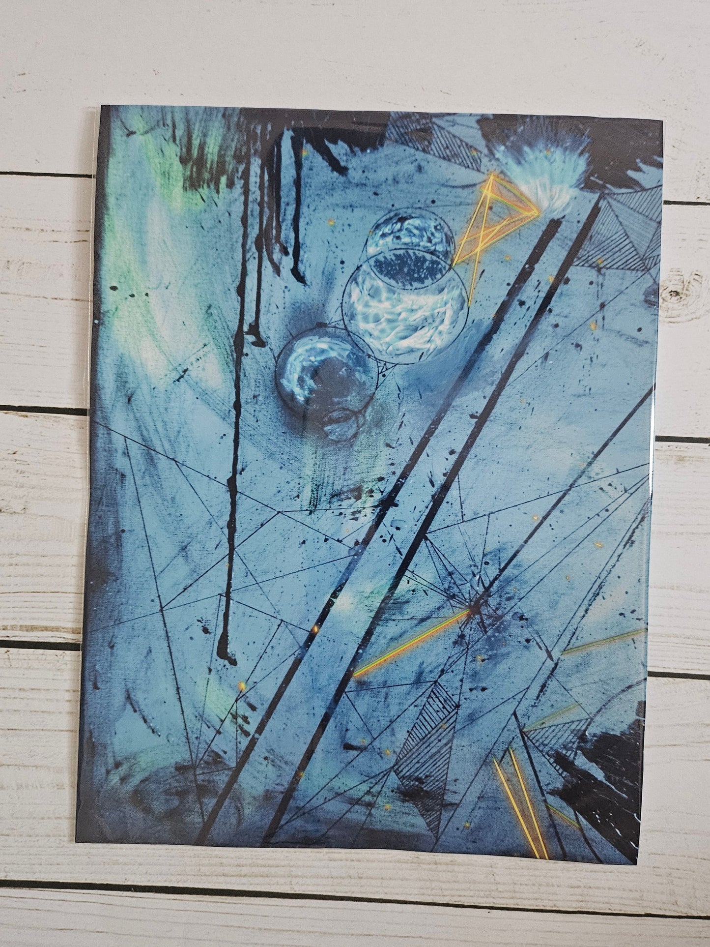 Abstract art piece with blue and black tones on a wooden surface